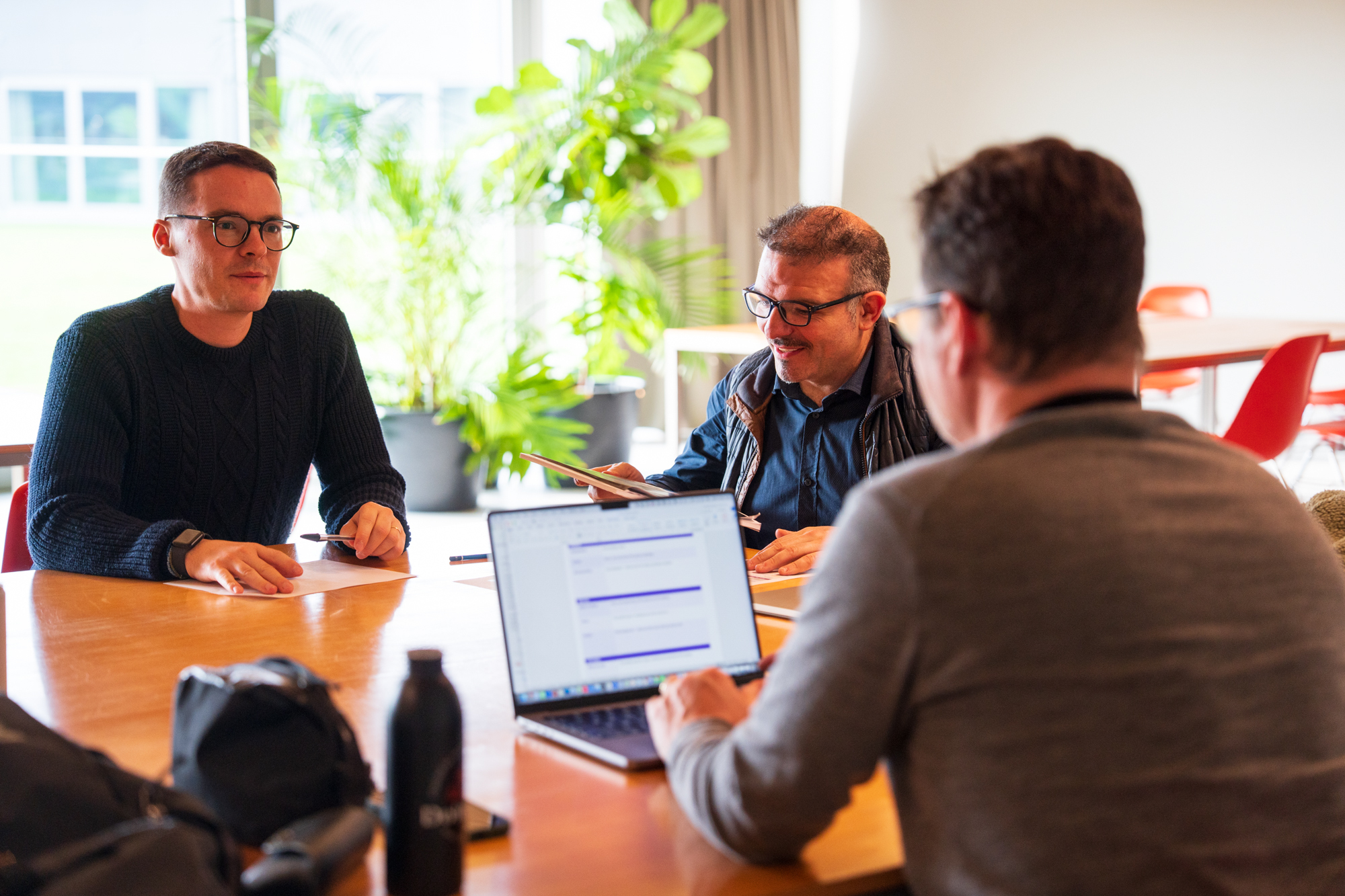 Two energy consultants reviewing portfolio data together on a laptop